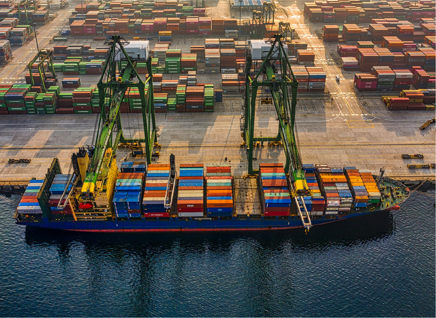 Container ship being loaded at a Chinese port at sunset